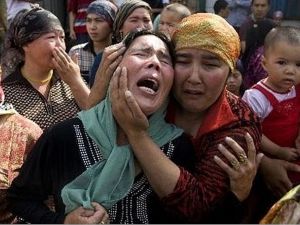 ارشيف/ نساء مسلمات ينتحبن اثر مقتل 15 شخصا في هجوم بالقنابل والسكاكين في منطقة شينجيانغ عام 2014
