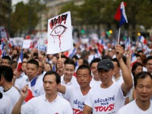 مشاركون في احتجاج للجالية الصينية في باريس يوم الأحد
