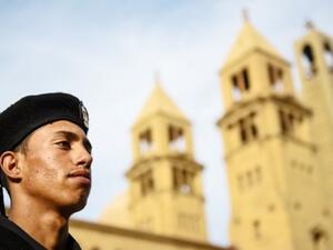 An Egyptian policeman stands guard in front of a church (AFP/File Photo)