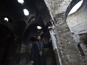 A Coptic priest stands inside what remains of a church after it was attacked by arsonists.  (AFP/Khaled Desouki)