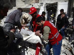 Members of the Syrian Arab Red Crescent and residents search through the rubble for bodies following an airstrike in the rebel-held city of Douma in Eastern Ghouta, on February 26, 2016. (AFP/Abd Doumany)