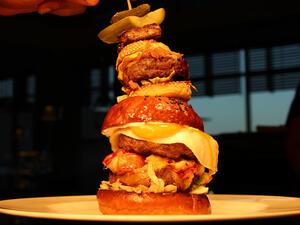 The Burger Khalifa is loaded with two beef patties, a Maine Lobster Tail, foie gras, black truffle aioli, and a sunny side egg. (Firebird Diner)