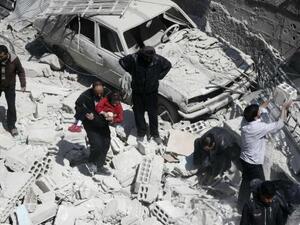 رجل يحمل طفلا وسط أنقاض مباني منهارة بعد ما قال نشطاء إنه ثمانية ضربات جوية للقوات السورية في منطقة دوما في الغوطة الشرقية بالقرب من دمشق
