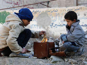 Syrian boys make a fire in Kafr Batna in the rebel-held Eastern Ghouta area, on the outskirts of the capital Damascus on Jan. 21, 2017 (AMER ALMOHIBANY/AFP)