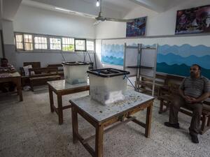 Egyptian officials sit in an empty polling station in Cairo's Giza district, on the second day voting in Egypt's parliamentary elections on October 19, 2015. (AFP/Khaled Desouki)