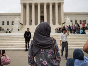 A woman wearing a hijab stands outside the court (AFP/File Photo)