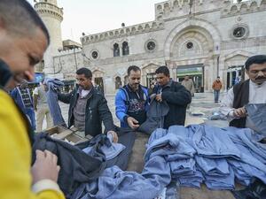 People buying clothes in front of Al-Husseini Mosque on December 9, 2016, in downtown Amman. (Shutterstock)