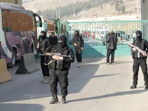 مقاتلون من جيش الفتح يخفرون منطقة خلال اجلاء بالحافلات مقاتلين ومدنيين من بلدتي الفوعة وكفريا الشيعيتين في ادلب 
