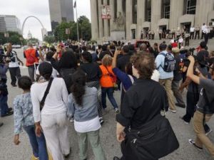 محتجون يسيرون في مقاطعة سانت لويس يوم الاثنين بمناسبة ذكرى مرور عام على مقتل شاب أسود.
