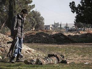 مقاتل في الجيش الحرّ يلقي نظرة على أحد عناصر جيش النظام 