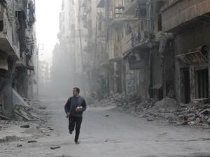 A Syrian rebel runs through a street in Aleppo during clashes with government troops. (AFP/File)