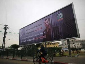  لافتة ضخمة في غزة تحمل صورة جندي إسرائيلي أسير لديها