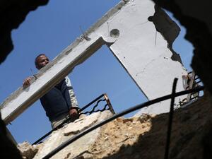 A Palestinian worker checks a house that was destroyed during the 50-day war between Israel and Hamas-led militants in the summer of 2014, east of Gaza City on March 23, 2016. (AFP/Mohammed Abed)