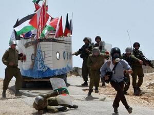 صحفي اجنبي يهرب من مطاردة جنود اسرائيليين خلال احتجاج في بلدة بعلين الفلسطينية، الجمعة،أ.ف.ب