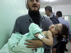 فلسطيني يحمل طفلا مصابا اثر غارة اسرائيلية/أ.ف.ب