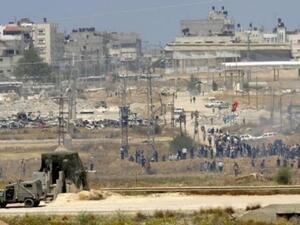 القوات الاسرائيلية تحرس جهتها على الحدود مع قطاع غزة فيما يتظاهر فلسطينيون في الجهة الاخرى