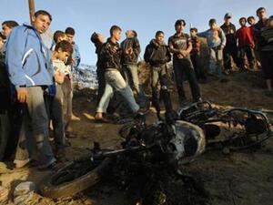 فلسطينيون يتجمعون حول دراجة نارية متفحمة ضربتها غارة جوية اسرائيلية على خان يونس الثلاثاء