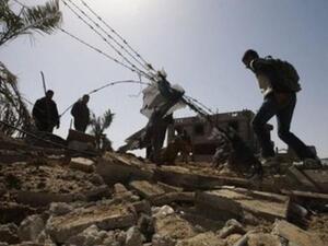 فلسطينيون يتفقدون موقع غارة اسرائيلية في قطاع غزة