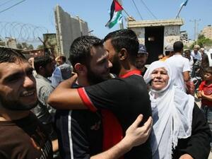 احد المفرج عنهم يعانق ذويه امام باب المعتقل/أ.ف.ب