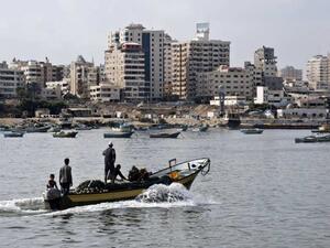 Fishermen ride a small boat into the harbour on August 18, 2014 in Gaza City. (ROBERTO SCHMIDT/AFP) 