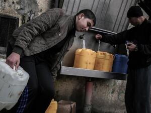 Palestinians fill bottles and jerrycans with drinking water from public taps at the Rafah refugee camp in southern Gaza Strip, on February 22, 2017. (Said Khatib/AFP/File)