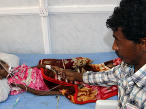 A Yemeni tends to his malnourished child as she receives treatment at a hospital in the Yemeni port city of Hodeidah. (AFP/File)