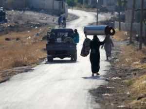 سكان يسيرون على طريق في سهل الغاب في ريف حماة
