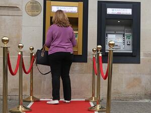 A woman uses a golden ATM on the 50th anniversary of the world's first cash machine. (Daniel Leal-Olivas/ AFP)