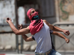 Palestinians throw stones towards Israeli forces during clashes in the West Bank town of Hebron. (AFP/File)