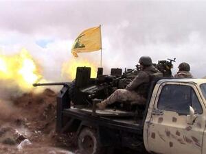 A handout picture released by the Hezbollah press office on May 16, 2015, shows a Hezbollah fighter firing toward areas controlled by militants on the Syrian side of the Qalamoun hills close to the Lebanese border. (AFP/File)