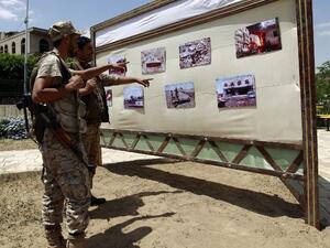 Shiite Houthi rebels look at photographs of destruction displayed in an exhibition condemning the Saudi-led military campaign on Sept. 17, 2015, in the Yemeni capital Sanaa. (AFP/Mohammed Huwais)