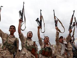 The fighters of the Houthi movement brandish their weapons during a rally against Saudi airstrikes. (AFP/File)