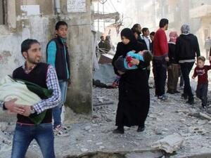 مدنيون يفرون باطفالهم من منطقة تعرضت لقصف من قبل قوات الاسد في حمص

