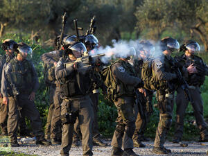 An Israeli security soldier fires a tear gas canister at Palestinian protesters. (AFP/File)