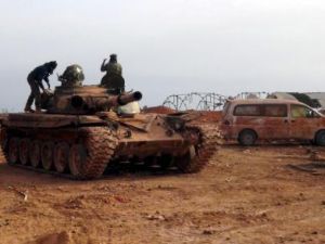 مقاتلون اسلاميون فوق دبابة غنموها من القوات الموالية للرئيس السوري بشار الاسد في شمال غرب البلاد
