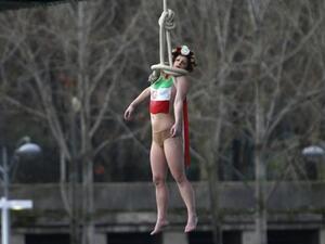 A Femen protester performs a mock hanging off a Parisian bridge (AFP/File)