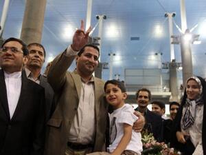 امير مع ابنه وزوجته خلال استقباله في المطار/أ.ف.ب