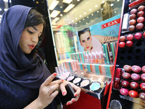 An Iranian woman checks make up at a cosmetics shop in northern Tehran on May 6, 2014. (AFP/Atta Kenare)