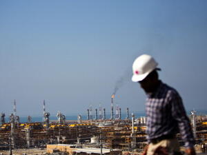 An Iranian worker walks near the phase 12 of the South Pars gas field facilities near the southern town of Kangan on the shore of the Gulf on Jan. 22, 2014. (AFP/Behrouz Mehri)