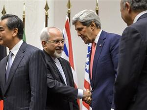 Iranian Foreign Minister Mohammad Javad Zarif shakes hands with US Secretary of State John Kerry after a statement to announce a landmark deal with Iran halting parts of its nuclear program. (AFP/File)
