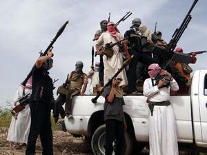 Iraqi armed tribesmen pose for a picture on the back of a truck in a road north of Ramadi, on May 18, 2013 (Azhar Shallal/ AFP)