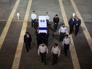 Israeli honour guards carry the coffin of former prime minister Ariel Sharon in to the Knesset (the Israeli Parliament) in Jerusalem at the end of the day on January 12, 2014 as Israelis came to pay their respects. [AFP]