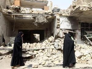 عراقيات وسط الدمار الذي احدثته تفجيرات الاثنين/أ.ف.ب