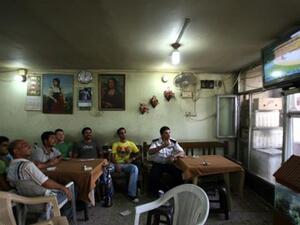 عراقيون يتابعون حفل افتتاح المونديال في احد مقاه بغداد الخميس/أ.ف.ب