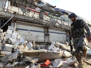 عسكري عراقي يتفقد اثار تفجير في بغداد/أ.ف.ب