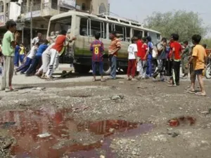 عراقيون يدفعون حافلة صغيرة تعرضت لهجوم في بغداد