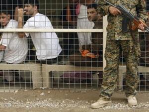 جندي عراقي يراقب سجناء في بغداد
