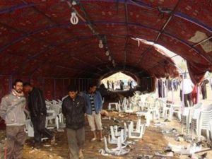 عراقيون يتفقدون موقع سرادق العزاء الذي هاجمه انتحاري في حي الشعلة في بغداد
