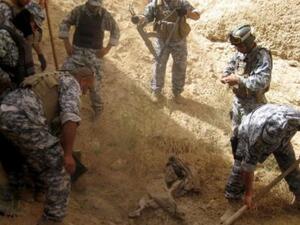 رجال امن عراقيون في موقع المقبرة الجماعية في الحلوة 