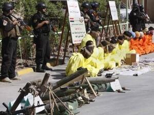 معتقلون معصوبو الاعين يجلسون امام رجال امن عراقيين في البصرة